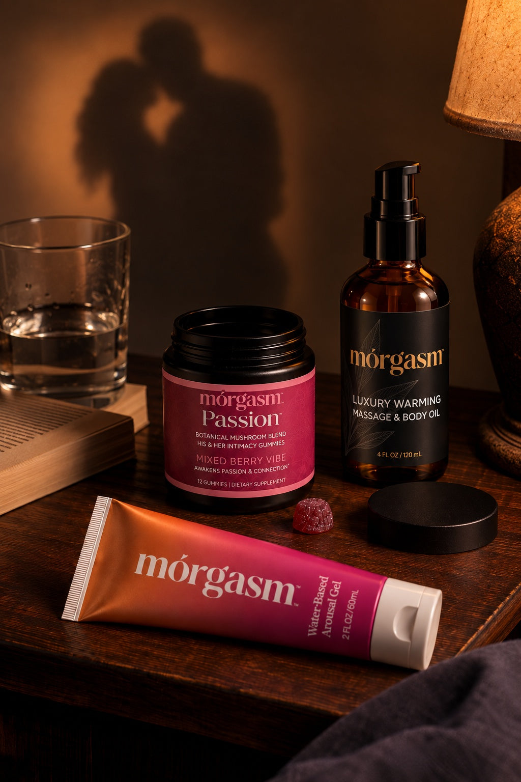Morgasm arousal gel, Passion gummies and warming massage oil on a bedside table