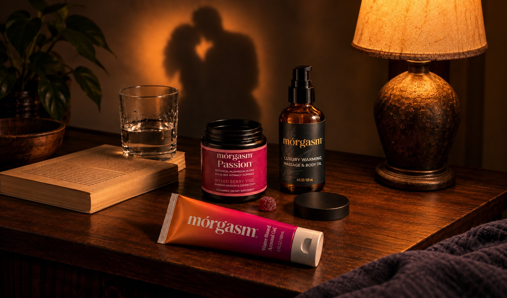 Morgasm arousal gel, Passion gummies and warming massage oil on a bedside table