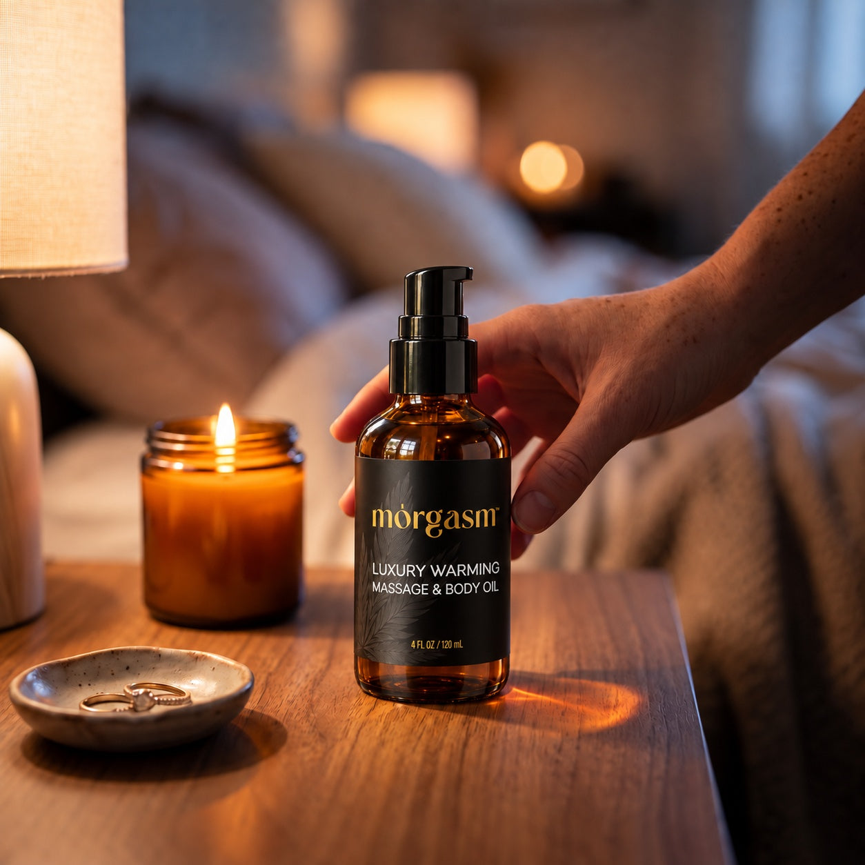 Reaching for the warming oil on a bedside table by candlelight